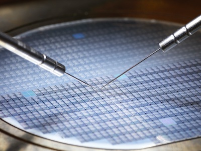 Scientist works on chips on a printed circuit board used in semiconductor facility