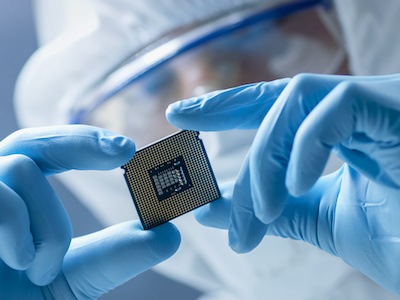 Researcher reviews semiconductor chip in semiconductor lab
