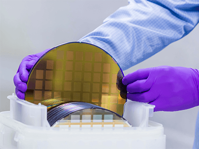 Semiconductor being carefully handled in a cleanroom.