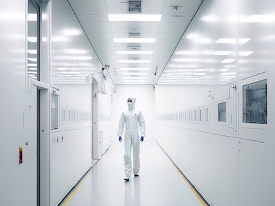 Scientist walking through a high-tech cleanroom space