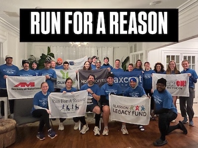 Run For a Reason racers posing together with sponsorship banners and signs