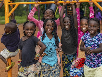Young children supported by Mercy Ministries pose together on the playground
